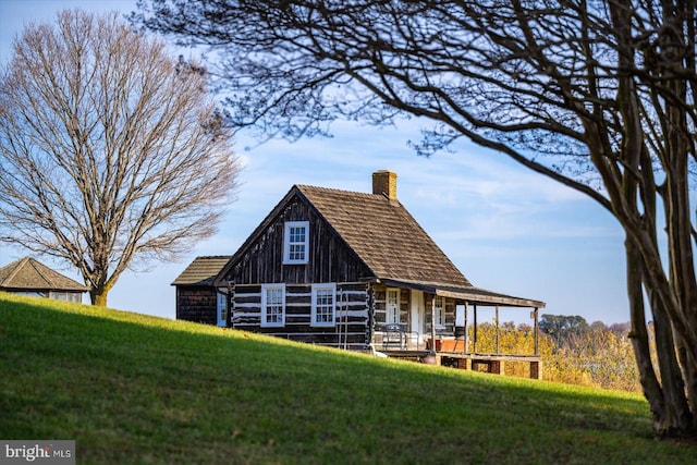 rear view of house with an outbuilding and a lawn