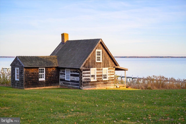 view of outdoor structure featuring a water view and a yard