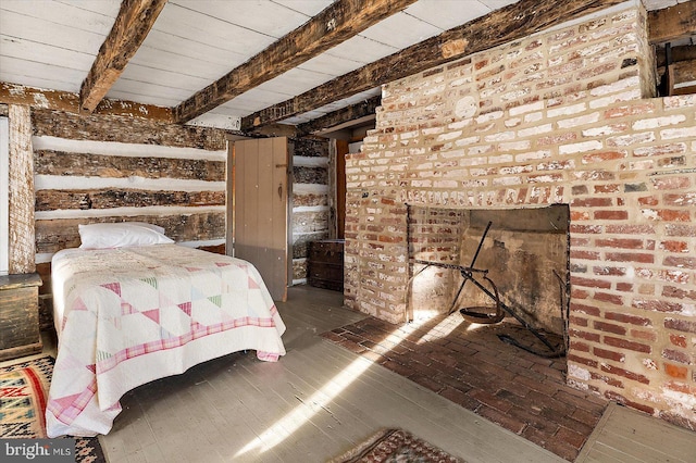 bedroom featuring brick wall and beam ceiling