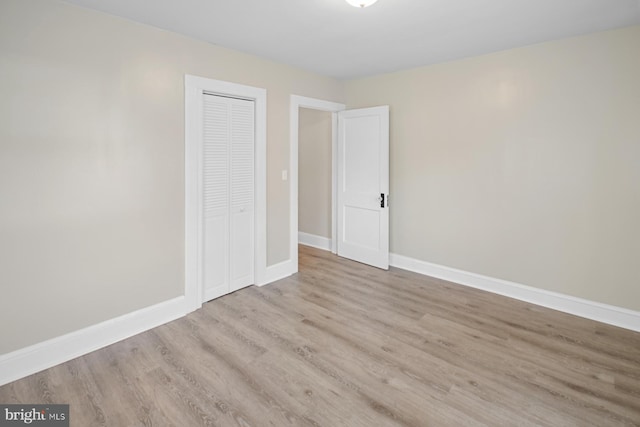 unfurnished bedroom with a closet and light hardwood / wood-style floors