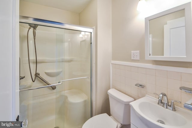 bathroom with walk in shower, vanity, toilet, and tile walls