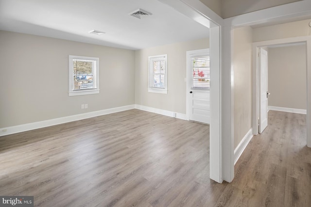 empty room with light hardwood / wood-style flooring and a healthy amount of sunlight