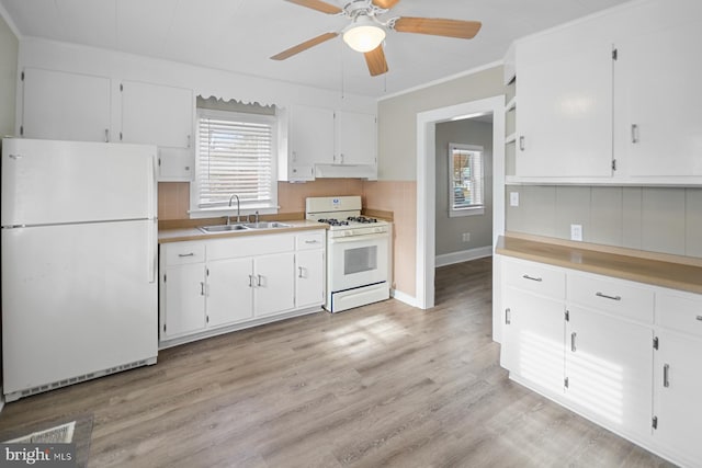 kitchen with white appliances, sink, light wood-type flooring, white cabinetry, and extractor fan