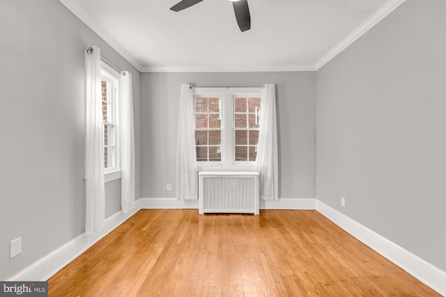 empty room featuring ceiling fan, crown molding, radiator, and light hardwood / wood-style flooring