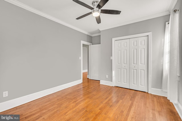 unfurnished bedroom featuring ceiling fan, a closet, ornamental molding, and light hardwood / wood-style flooring