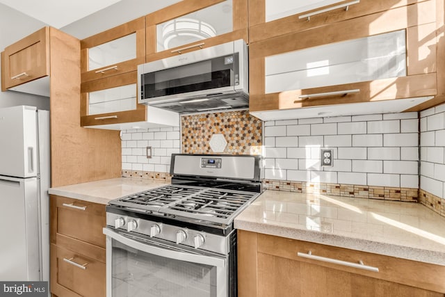 kitchen featuring light stone countertops, stainless steel appliances, and tasteful backsplash