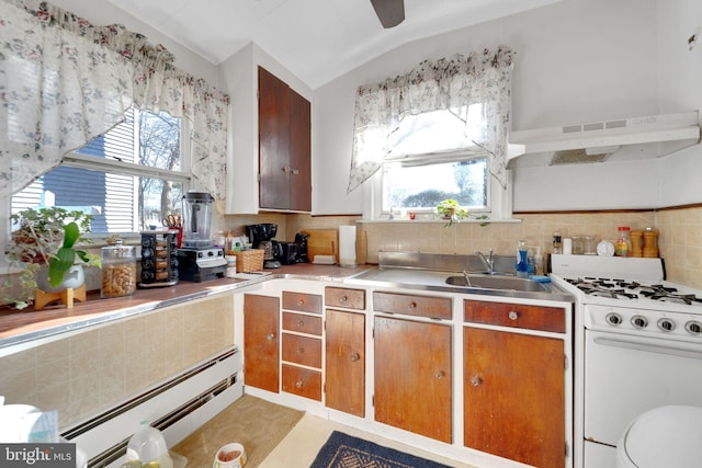 kitchen featuring a baseboard radiator, vaulted ceiling, a healthy amount of sunlight, and gas range gas stove