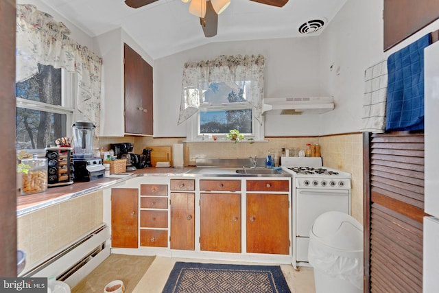 kitchen with lofted ceiling, sink, ceiling fan, baseboard heating, and white range with gas cooktop