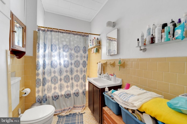 bathroom featuring tile walls, vanity, and toilet