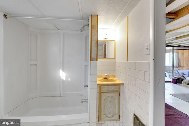 bathroom featuring vanity, tile walls, and shower / bathtub combination