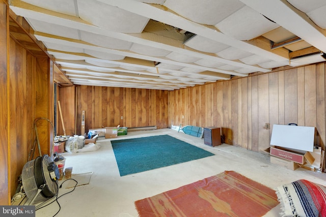 interior space with a baseboard heating unit and wood walls