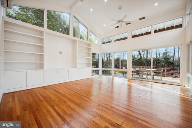 unfurnished living room with hardwood / wood-style floors, ceiling fan, beamed ceiling, and high vaulted ceiling