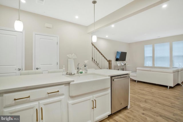 kitchen featuring white cabinetry, sink, dishwasher, pendant lighting, and light wood-type flooring