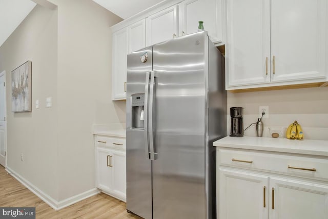 kitchen with white cabinets, light hardwood / wood-style floors, and stainless steel refrigerator with ice dispenser