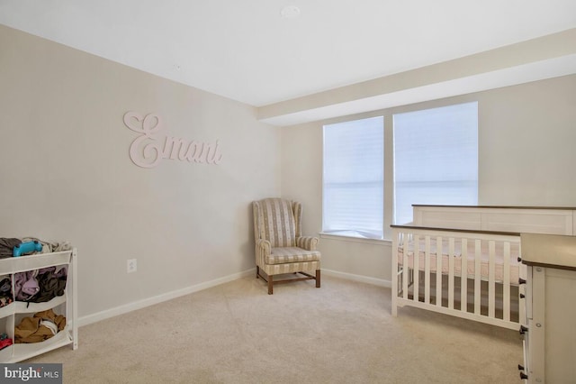 bedroom featuring light carpet and a crib