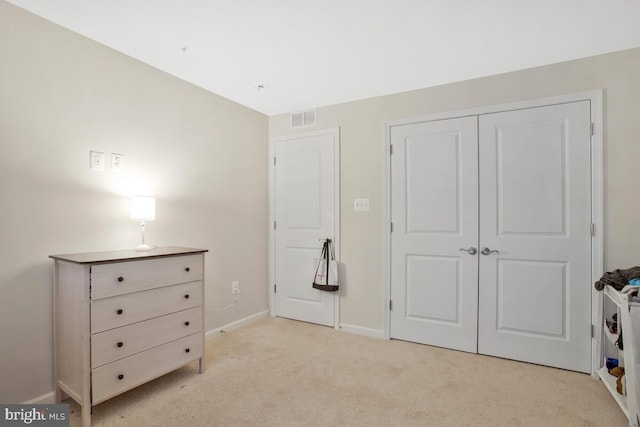 unfurnished bedroom featuring light carpet and a closet