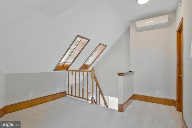 bonus room featuring a wall mounted AC, lofted ceiling with skylight, and carpet flooring