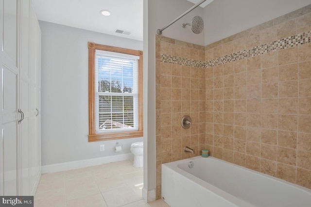 bathroom with tile patterned floors, toilet, and tiled shower / bath combo