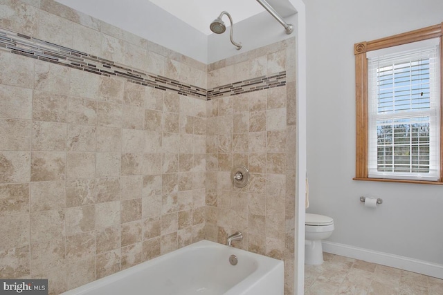 bathroom with toilet and tiled shower / bath