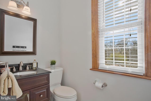 bathroom featuring toilet, plenty of natural light, and vanity