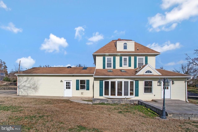 rear view of property featuring a patio area and a lawn