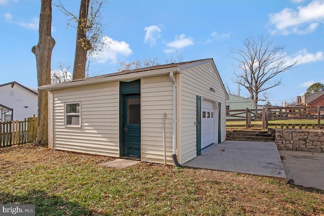 view of outdoor structure with a garage and a lawn