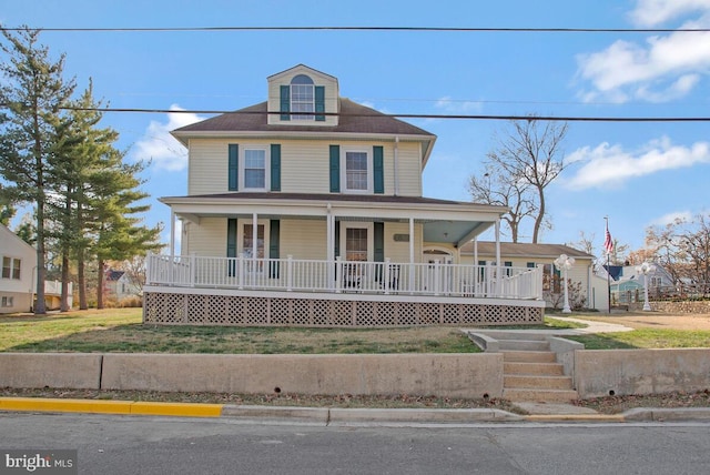 farmhouse with covered porch and a front yard