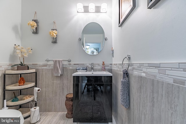 bathroom featuring vanity and tile walls