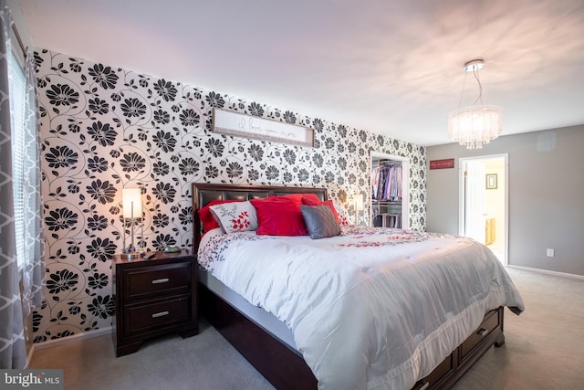 bedroom with light carpet, ensuite bathroom, and a notable chandelier