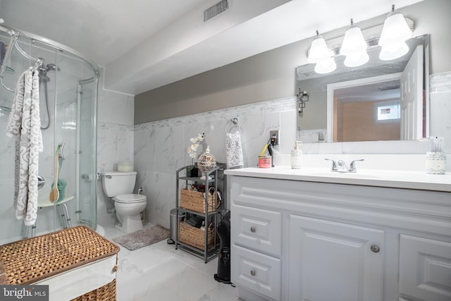 bathroom with vanity, toilet, and a shower with door