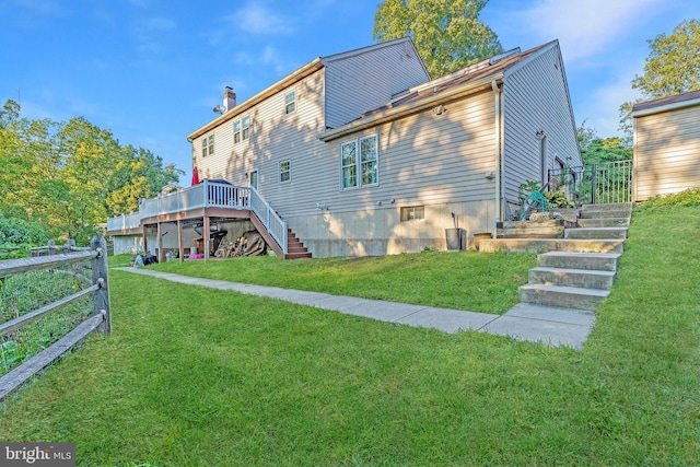 rear view of property featuring a lawn and a wooden deck