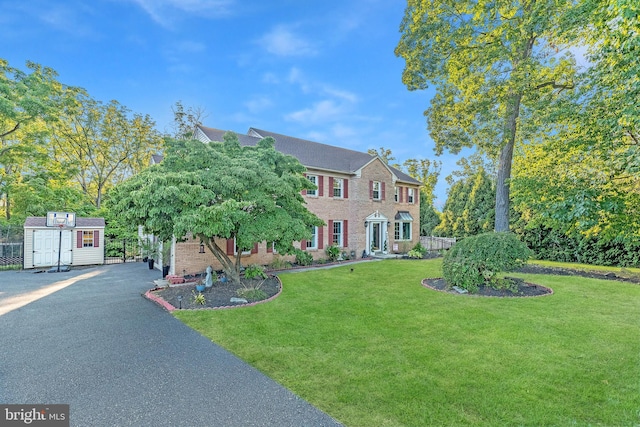 view of front of property featuring a shed and a front lawn