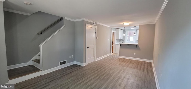 interior space with sink, dark wood-type flooring, and ornamental molding