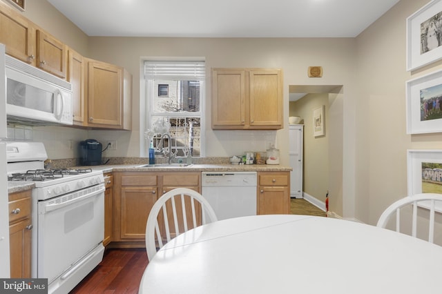 kitchen with backsplash, light brown cabinetry, sink, and white appliances