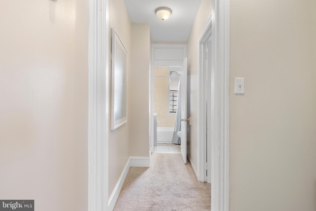 hallway featuring light colored carpet