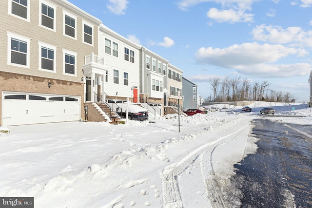 snow covered property with a garage