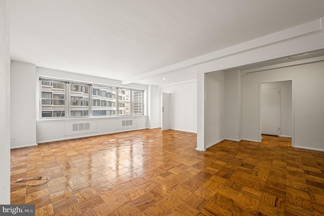 spare room with beam ceiling and parquet flooring