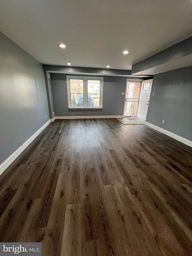 empty room with dark hardwood / wood-style flooring