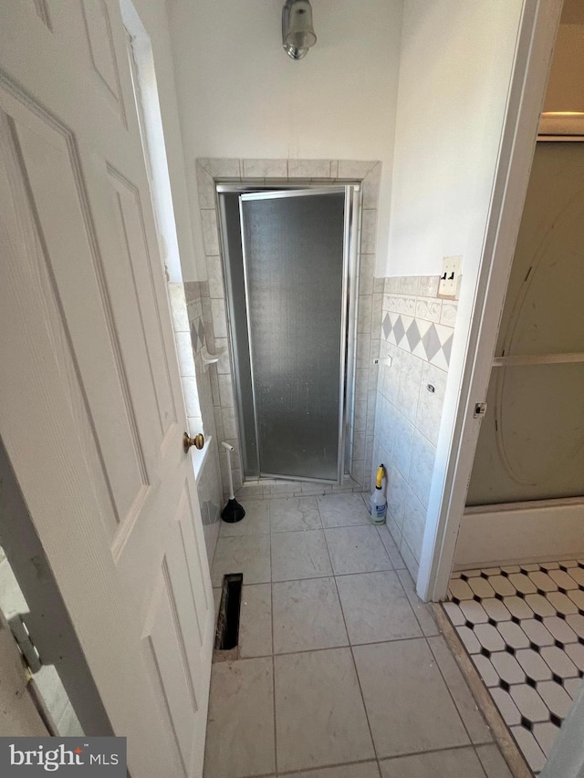 bathroom with tile patterned flooring and tile walls