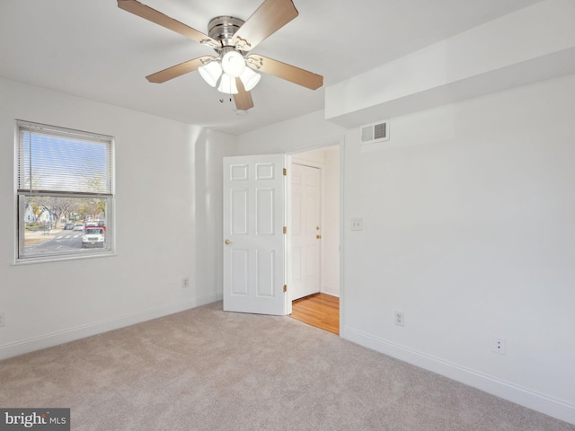 carpeted spare room featuring ceiling fan