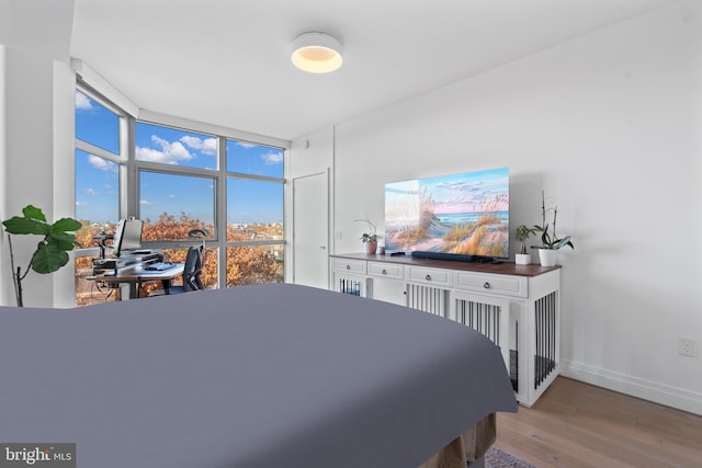 bedroom featuring hardwood / wood-style floors and expansive windows