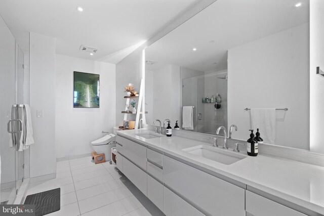 bathroom featuring tile patterned floors, vanity, and a shower with shower door