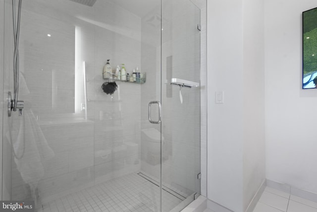 bathroom with tile patterned flooring and a shower with door