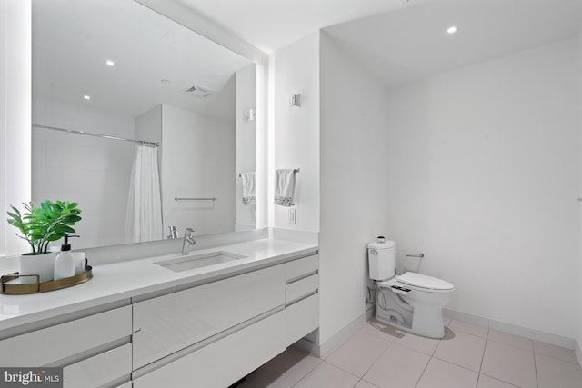 bathroom with a shower with curtain, vanity, toilet, and tile patterned floors