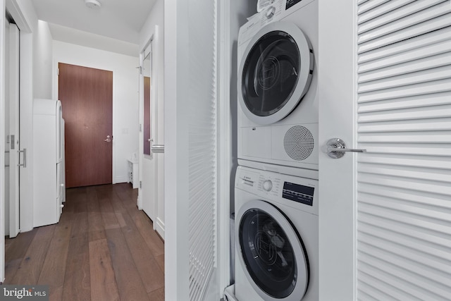 washroom with stacked washer and dryer and dark hardwood / wood-style floors