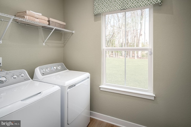 clothes washing area featuring separate washer and dryer and hardwood / wood-style flooring