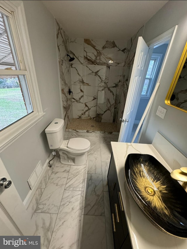 bathroom featuring vanity, toilet, and tiled shower