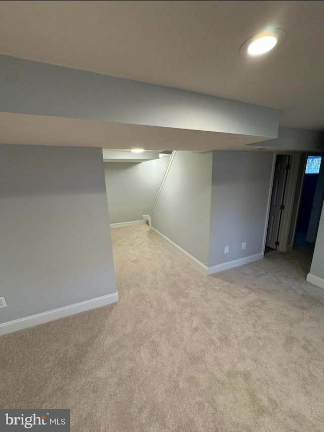 basement featuring light carpet