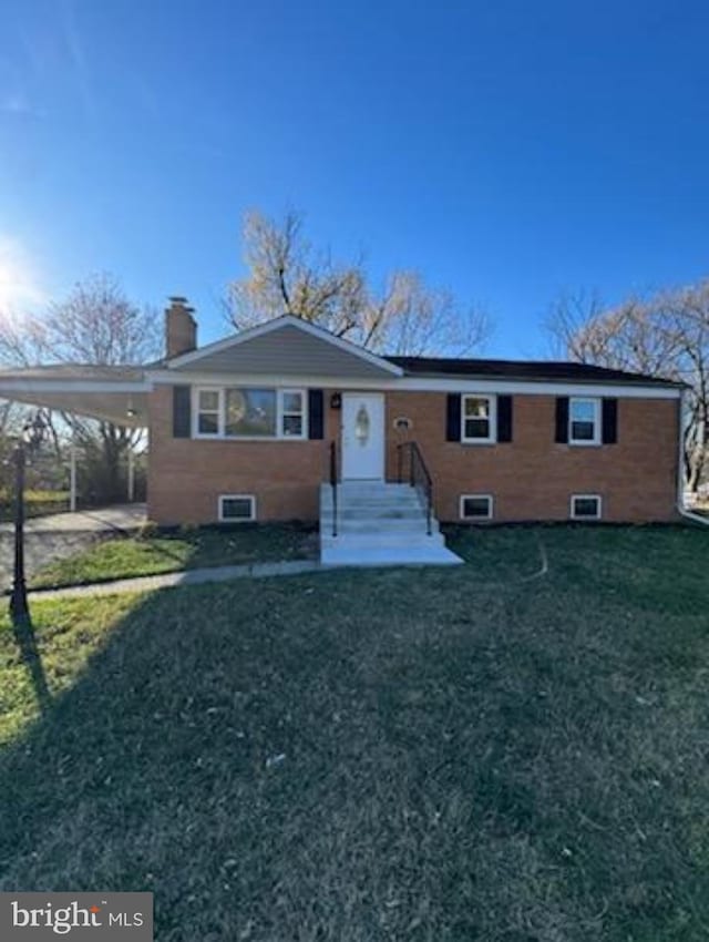 view of front of house featuring a carport, brick siding, a front lawn, and a chimney