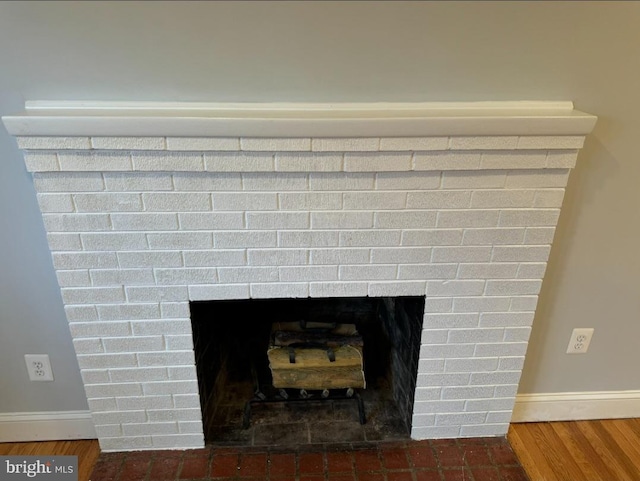 details with hardwood / wood-style floors and a brick fireplace